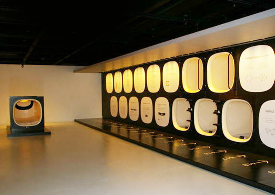 A corridor of stacked sleeping capsules lit from within.